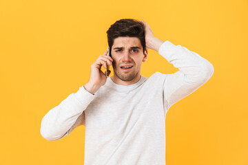 Photo of unhappy unshaven sick man talking on smartphone at camera