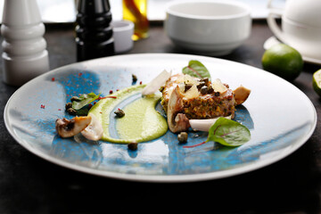 Grilled tuna steak with pistachio nuts, capers and green peas. Tasty dish on a blue plate. Food photography.