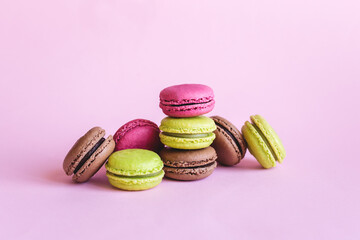 Set of tasty french macaroons on a pink background.