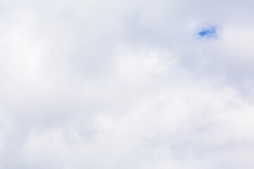 continuous clouds with a small hole through which the blue sky shines through