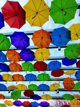 Colorful umbrellas hanging from a ceiling overhead