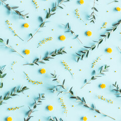 Flowers composition. Yellow flowers, eucalyptus branches on blue background. Spring concept. Flat lay, top view