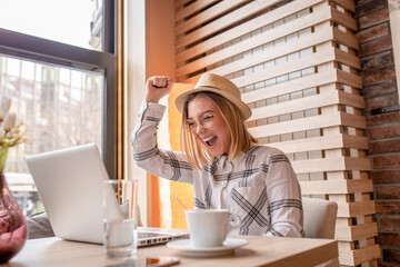 Portrait of young woman using laptop at cafe, she is working on laptop computer at a coffee shop.	