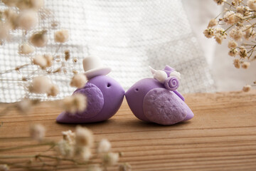 Decorative pair of birds in a wedding look on a wooden background with hearts. Wedding concept