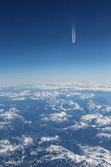 Widok z samolotu na góry Alpejskie. Śnieg na górach gór. Na horyzoncie ślady od innego samolotu. - obrazy, fototapety, plakaty