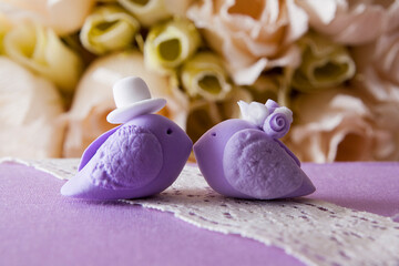 Obraz na płótnie Canvas Wedding birds on a lilac background with flowers. Wedding day concept