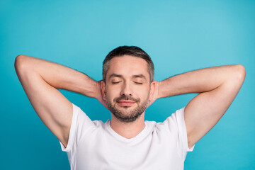 Close-up portrait of his he nice attractive dreamy bearded guy wearing tshirt holding hands behind head resting isolated over bright vivid shine vibrant blue color background