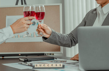 Two businessmen are sipping wine in the office, working to celebrate the success of the company business,success and winning concept.
