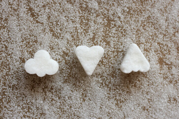 White sugar candies in different shapes  on the background of sugar