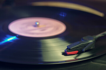 Retro record player with a spinning vinyl record reflecting green and blue lights