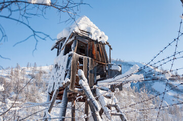 Ruins of wooden prison observation tower of labour camp GULAG in Verkhoyansk Range in Yakutia during cold winter day, Russia. The construction of the Kolyma highway aka Road of bones