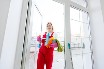 Beautiful young woman makes cleaning the house. Girl rubs dust.