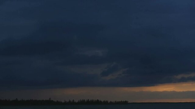 The sky is in zagon with clouds above the pond. Sunset time.