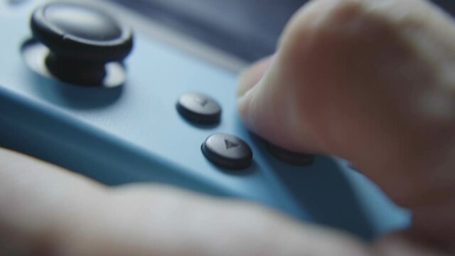 close up of a finger pressing a button om a game controller