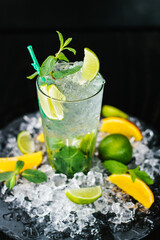 A glass of fresh Mojito. Lime, orange and mint. On a wooden background