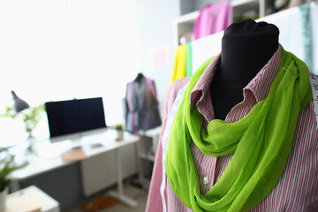 Close up of stylish green scarf and striped shirt on female dressmaker mannequin in tailor shop