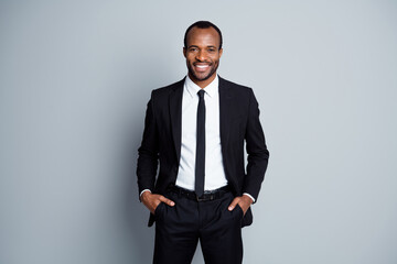 Portrait of his he nice attractive cheerful cheery guy employee banker financier wearing fashionable brandy suit holding hands in pockets posing isolated over grey pastel color background