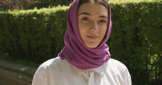 Beautiful young woman looking at camera, wearing traditional headscarf. Attractive Female in hijab