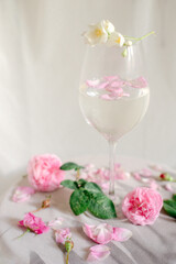 Glass with water and roses on the table