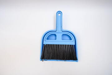 A small blue wastebasket and a blue broom on a white background for easy housekeeping