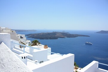 snow-white houses stand on a mountain on the island of Santorini. View of the sea and passing ships