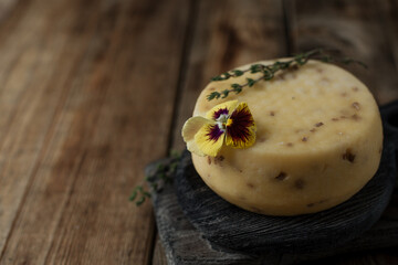 A whole head of cheese on a wooden cutting board