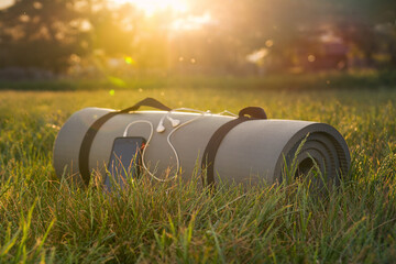 Obraz premium yoga Mat and phone in the sunset sun, in soft focus, close-up