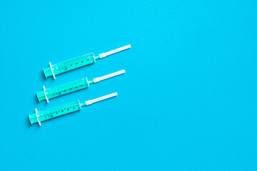 Top view of syringes in a row for medical injection on colorful background with copy space. Health and vaccination concept