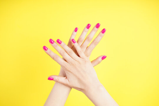 Beautiful hands of a young woman on a yellow background. Beautiful manicure close-up.