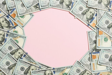 Frame of one hundred dollar bills with empty space for your design. Top view of business concept on pink background with copy space