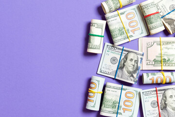 Stacks of one hundred dollars banknotes close-up on colored background business concept top view with copy space