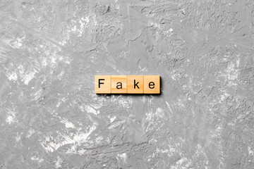Fake word written on wood block. Fake text on cement table for your desing, concept