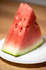 Slices of pounded juicy red watermelon on a white plate.