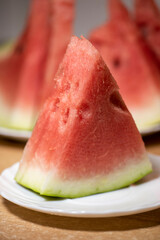 Slices of pounded juicy red watermelon on a white plate.