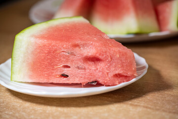 Slices of pounded juicy red watermelon on a white plate.