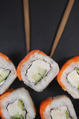 Japanese rolls on black stone background.