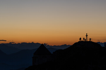 silhouette of hikers on a peak of a mountain top