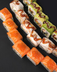 Japanese rolls on black stone background.