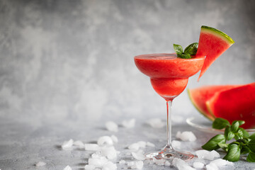A frozen red drink garnished with watermelon and basil. Frozen margarita.