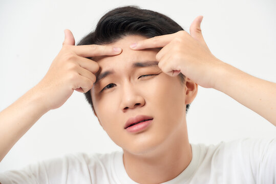 Close up photo of young man looking for acnes on his face