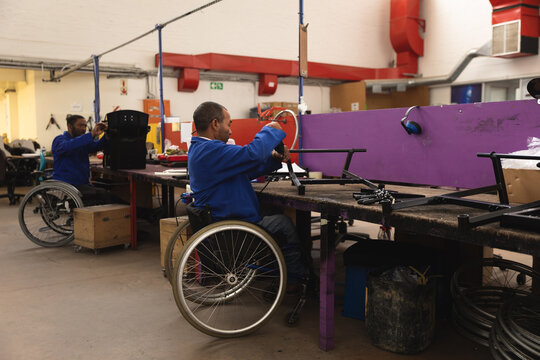 Multi races workers assembling wheelchairs parts