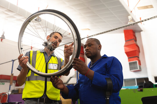 Multi races workers inspecting a wheel