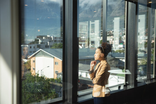 Mixed race business woman thoughtful and looking outside