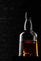 Whisky bottle close up against black grunge wall