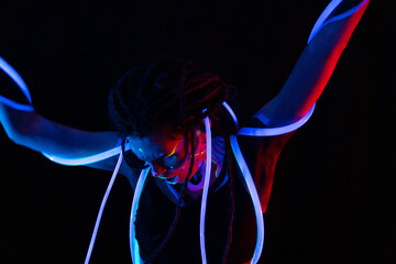 Portrait of a Warror Girl with Glowing Tubes in Neon UF Light. Model Girl with Dreadlocks and Fluorescent Creative Psychedelic MakeUp, Art Design of Female Disco Dancer Model in UV, Colorful Abstract