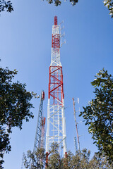 Huge telecommunication tower in the middle of the field.