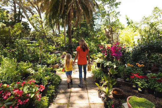 A Caucasian woman and her daughter enjoying time together in a sunny garden