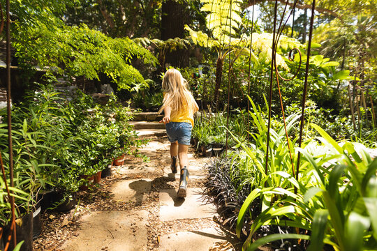 A Caucasian girl exploring a sunny garden