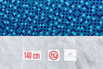 no diving and depth sign warning at swimming pool edge with copy space