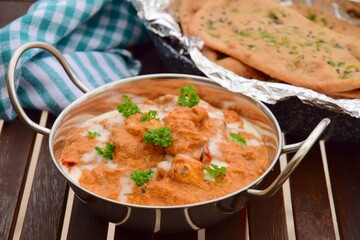 Murgh Makhani or butter chicken served with homemade whole wheat garlic Naan bread